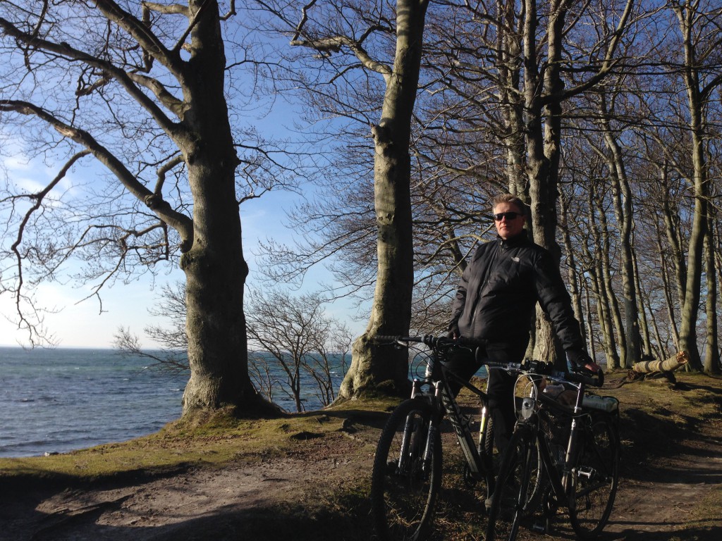 Per i skarp forårssol på cykel med morgenbrød fra Faxe Ladeplads på vej gennem skoven til Vemmetofte