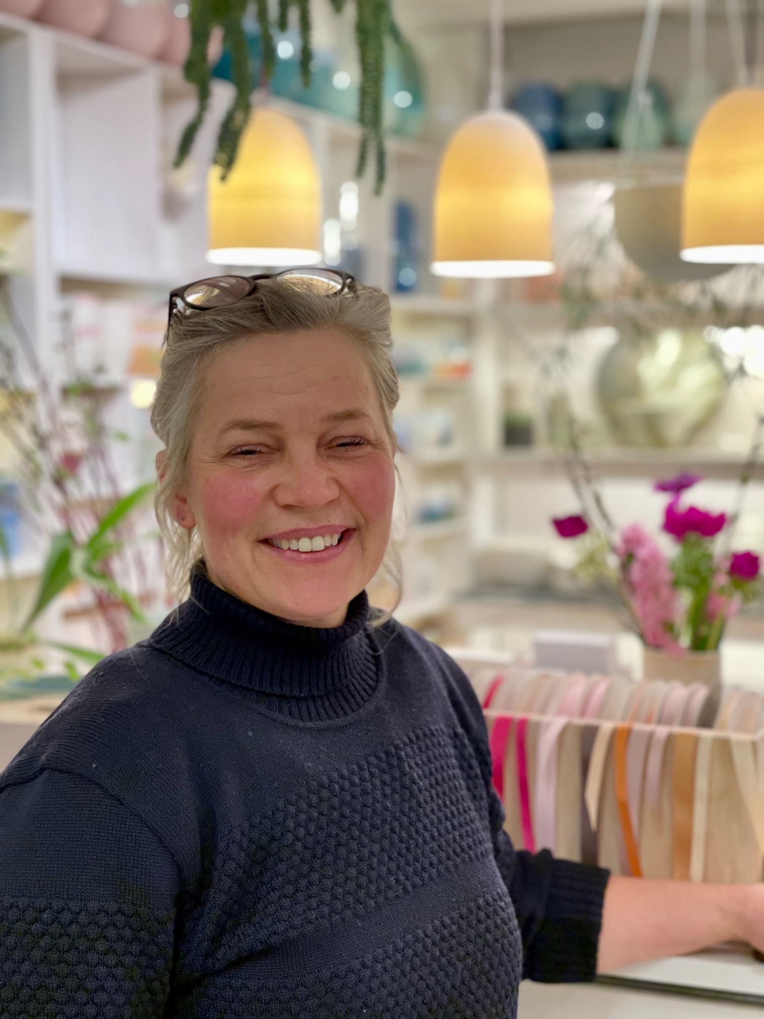 Keramiker Sussi Krull står i sin smukke værkstedsbutik i København, hvor man i baggrunden ser et udvalg af hendes unikke keramik. Billedet er taget af Vibeke Lahrmann